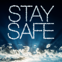 Words Stay Safe over blue sky with puffy white clouds underneath.